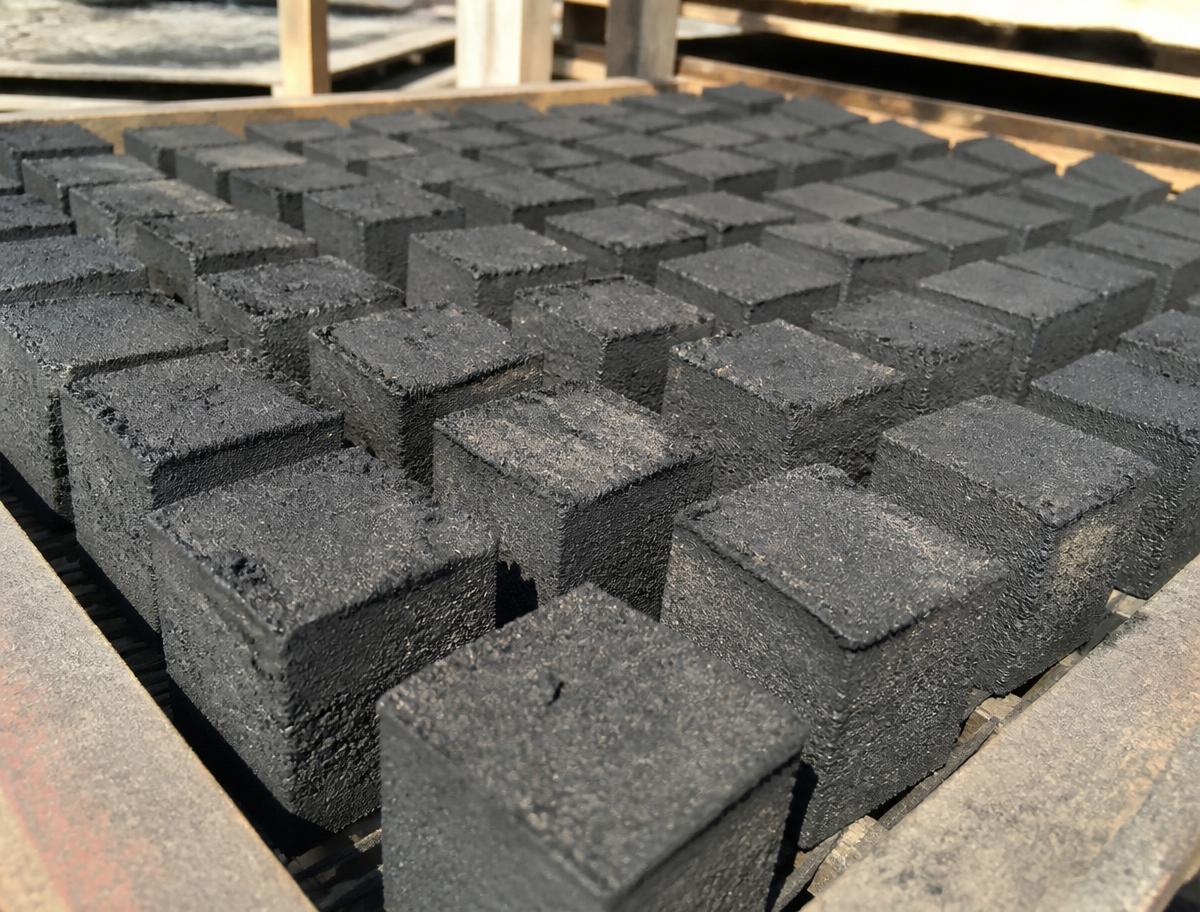 Cube-shaped coconut shell charcoal briquettes during production